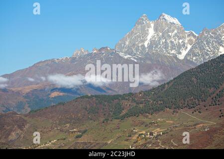 Le mont Ushba, l'un des sommets des montagnes du Caucase et des maisons de village en Géorgie Banque D'Images