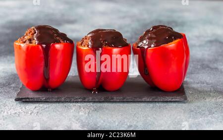 Poivrons rouges farcis avec de la sauce barbecue sur le conseil de pierre Banque D'Images