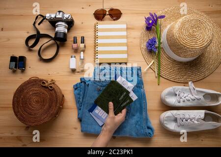 Femme méconnaissable mettant des passeports avec des billets d'avion sur des jeans tout en préparant des vacances Banque D'Images