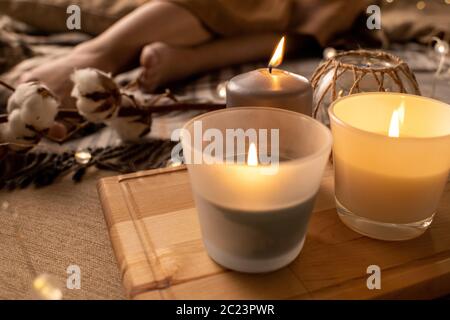Gros plan de bougies odorantes sur plateau en bois placé sur le lit pour l'aromathérapie Banque D'Images