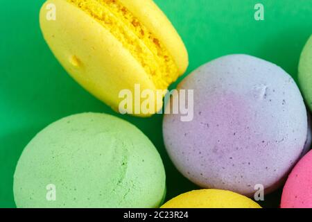 Macarons macarons colorés ou les cookies sur fond vert. Vue de dessus Banque D'Images