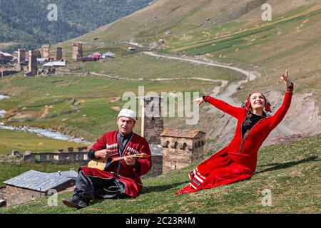 Danse de la femme géorgienne et l'homme géorgien joue un instrument de musique de Panduri, à Ushguli, en Géorgie. Banque D'Images