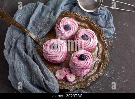 Guimauve rose lumineuse ronde avec des bleuets sur une plaque de fer, vue du dessus Banque D'Images