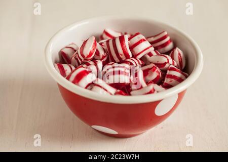 bonbons à la menthe poivrée rouge dans un bol rouge Banque D'Images