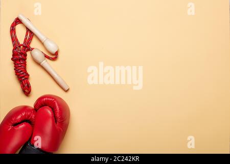 Forme physique encore la vie. Accessoires de sport avec gants de boxe rouges et corde à sauter sur fond jaune. Maquette. Planification des formations. Vue de dessus avec copie Banque D'Images