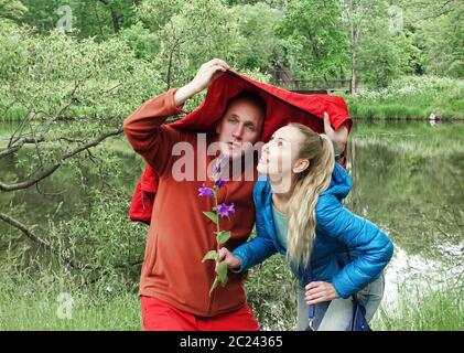 homme et femme se cachant de la pluie sur le lac Banque D'Images