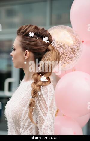 Superbe Slim brunette à fleurs dans ses cheveux et robe blanche. Banque D'Images