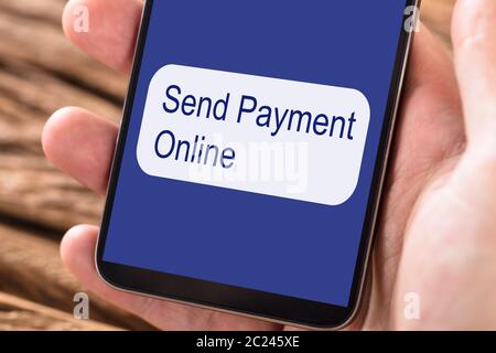 Personne utilisant Mobilephone pour envoyer le paiement en ligne Banque D'Images