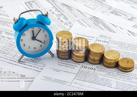 Heures, des piles de pièces de monnaie, reçu avec l'intérêt couru sur le paiement de l'électricité Banque D'Images