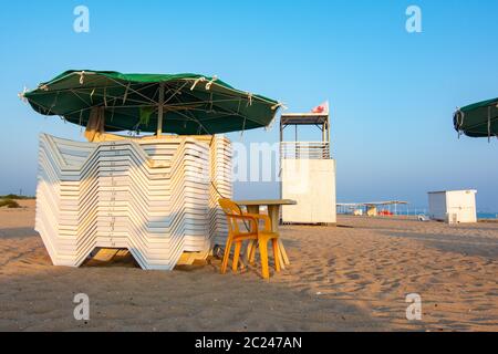 Des chaises longues et un plié sauveteur vide post sur une plage de sable déserte Banque D'Images