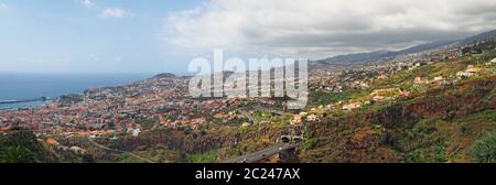 vue panoramique sur funchal à madère montrant la ville entourée de collines et de montagnes avec des forêts et un pont autoroutier Banque D'Images