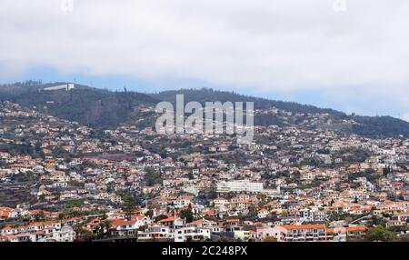 vue panoramique aérienne de funchal à madère avec des bâtiments qui s'élèvent sur les collines et des nuages blancs au-dessus des montagnes Banque D'Images