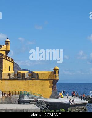 les touristes se détendent au bord de la mer à l'extérieur du fort jaune de funchal madère, sous un soleil éclatant Banque D'Images