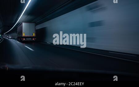 Les voitures sur une route allant à travers un long tunnel moderne (motion image floue ; couleur tonique libre) Banque D'Images