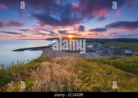 West Bay, Dorset, Royaume-Uni. 16 juin 2020. Météo Royaume-Uni. Un coucher de soleil spectaculaire à West Bay dans Dorset, les nuages deviennent rouges à la fin d'une chaude journée ensoleillée. Crédit photo : Graham Hunt/Alay Live News Banque D'Images