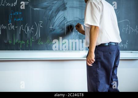 Enseignant l'enseignement des mathématiques en pointant sur tableau noir en classe Banque D'Images