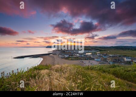 West Bay, Dorset, Royaume-Uni. 16 juin 2020. Météo Royaume-Uni. Un coucher de soleil spectaculaire à West Bay dans Dorset, les nuages deviennent rouges à la fin d'une chaude journée ensoleillée. Crédit photo : Graham Hunt/Alay Live News Banque D'Images