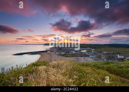 West Bay, Dorset, Royaume-Uni. 16 juin 2020. Météo Royaume-Uni. Un coucher de soleil spectaculaire à West Bay dans Dorset, les nuages deviennent rouges à la fin d'une chaude journée ensoleillée. Crédit photo : Graham Hunt/Alay Live News Banque D'Images