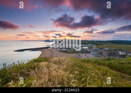 West Bay, Dorset, Royaume-Uni. 16 juin 2020. Météo Royaume-Uni. Un coucher de soleil spectaculaire à West Bay dans Dorset, les nuages deviennent rouges à la fin d'une chaude journée ensoleillée. Crédit photo : Graham Hunt/Alay Live News Banque D'Images