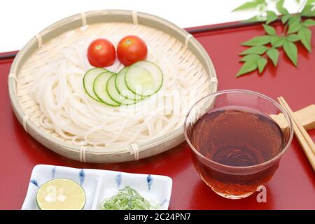 Nouilles somen japonais dans un plat en bambou avec de la sauce soja sur fond blanc Banque D'Images