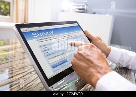 Close-up of Businessman Looking At Online Formulaire d'enquête sur la tablette numérique Banque D'Images