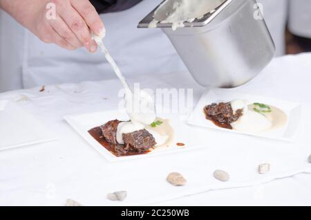 Joues de boeuf braisé à la bière avec purée de céleri-rave avec wasabi, gingembre mousse - chef preparing Banque D'Images