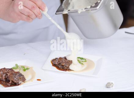 Joues de boeuf braisé à la bière avec purée de céleri-rave avec wasabi, gingembre mousse - chef preparing Banque D'Images