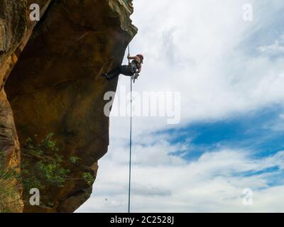 Descente d'un mur de roche de pierre à poncer négatif avec ciel bleu sur fond Banque D'Images