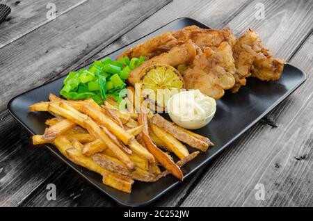 Poisson-frites avec mayonnaise maison sur la plaque noire Banque D'Images