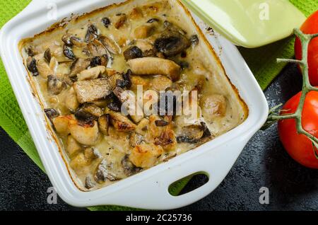 Poulet au four avec des champignons et de la crème, épicé de croustilles cuites au four Banque D'Images