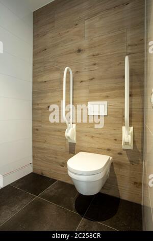 Toilettes à l'intérieur avec poignées pour personnes âgées ou handicapées, concept de désactivation. Design moderne propre et neuf Banque D'Images