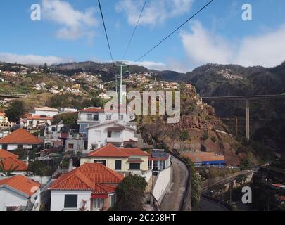 vue sur les maisons et les jardins du marché de funchal depuis le téléphérique qui monte sur la montagne jusqu'à monte avec pont routier et pe Banque D'Images