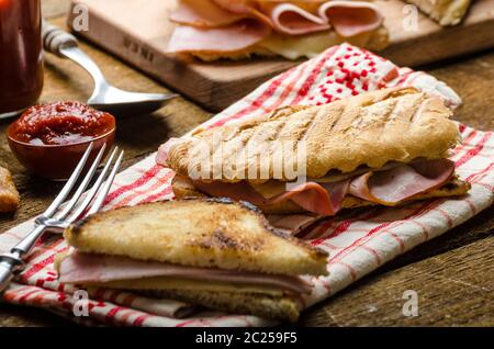 Dîner rapide, des toasts avec du jambon et fromage - panini, french toast, beurre, dessert français avec de délicieux churros Banque D'Images