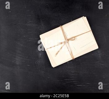 Vieilles cartes papier blanc vide attachés avec une corde sur un fond en bois noir, copy space Banque D'Images