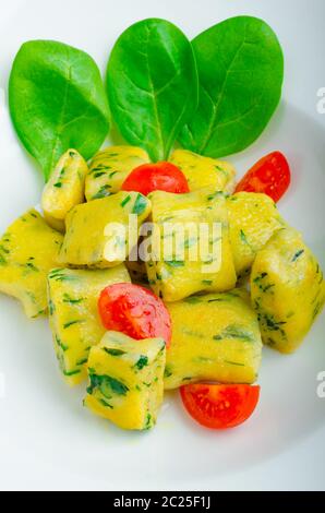 Gnocchi aux épinards avec du beurre fondu et les tomates cerise du jardin Banque D'Images