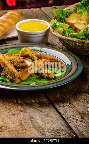 Poulet en croûte de maïs aux épinards et toasts, miel-moutarde de Dijon trempette, du pain baguette Banque D'Images