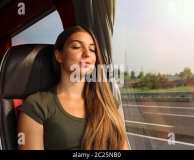 Belle jeune femme dormir assis dans le bus. Passagers par autobus voyageant assis dans un siège et dormir. Banque D'Images