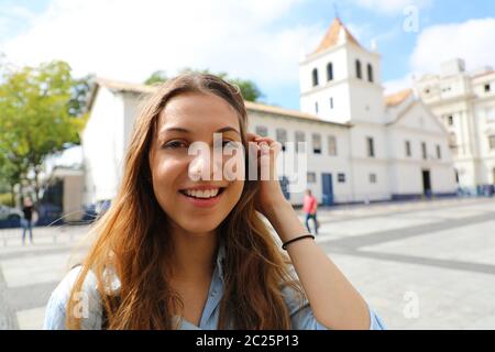 Happy smiling young woman in Sao Paulo centre ville avec Patio do Colegio vue sur l'arrière-plan, Sao Paulo, Brésil Banque D'Images