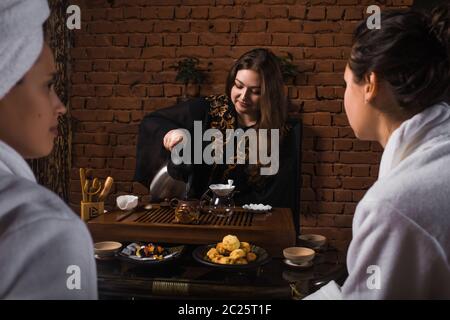 Cérémonie de thé après le sauna. Les filles en manteaux blancs boivent du thé chinois. Banque D'Images