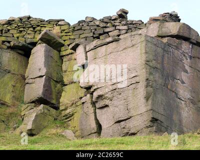 un grand affleurement rocheux avec un mur en pierre le long du sommet dans les landes du yorkshire Banque D'Images