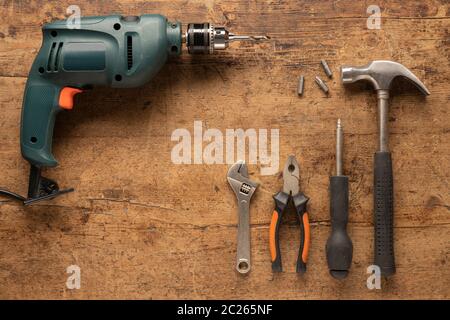 Forer et utiliser des outils à main sur un fond en bois vintage Banque D'Images