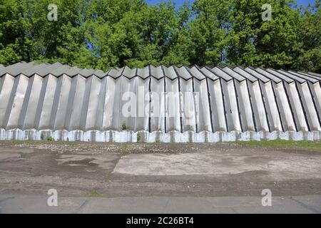 Hangar industriel avec murs en aluminium et supports de toit sur une fondation en béton près des arbres verts Banque D'Images