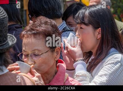 Une femme japonaise boit du thé au sanctuaire Kameido Tenjin, Tokyo, Japon