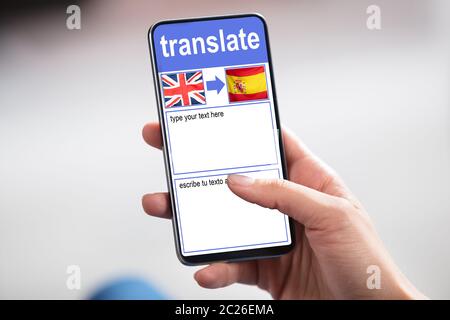 Personne Holding Smartphone montrant avec Application langue Translate drapeau du pays Banque D'Images