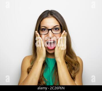 Image d'une femme excitée portant des lunettes et vêtue de drees verts sur fond blanc. Regardez la caméra. Banque D'Images