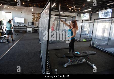 Los Angeles, Californie, États-Unis. 16 juin 2020. Peet Sapsin, propriétaire et entraîneur de fitness d'inspire South Bay Fitness, dirige les gens s'exercer derrière des feuilles de plastique dans leurs boîtiers d'entraînement tout en observant les distances sociales le 16 juin 2020 à Redondo Beach, Californie, alors que la salle de gym rouvre en vertu des directives de réouverture de la phase 3 du coronavirus de Californie. Crédit : Ringo Chiu/ZUMA Wire/Alay Live News Banque D'Images