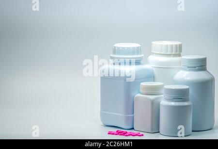 Comprimés roses avec flacon fermé d'étiquette vierge sur fond blanc avec espace de copie. Pile de comprimés de salbutamol. Médecine pour le traitement de l'asthme. Asthm Banque D'Images