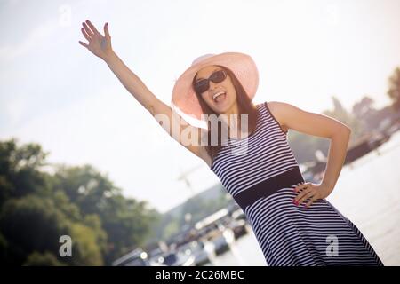 La femme attirante en vêtements d'été fait des orageuses à l'extérieur et dit Bonjour. Banque D'Images