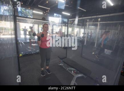 Los Angeles, Californie, États-Unis. 16 juin 2020. Les gens s'exercent à inspire South Bay Fitness derrière des feuilles de plastique dans leurs boîtiers d'entraînement tout en observant la distance sociale le 16 juin 2020 à Redondo Beach, Californie, alors que la salle de gym rouvre en vertu des directives de réouverture de la phase 3 du coronavirus de Californie. Crédit : Ringo Chiu/ZUMA Wire/Alay Live News Banque D'Images