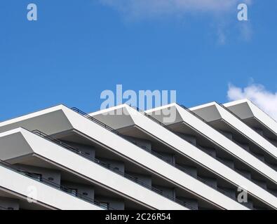 détails d'angle d'un appartement moderne blanc géométrique bloc de balcons géométriques diagonaux et des balustrades contre un ciel bleu clair Banque D'Images